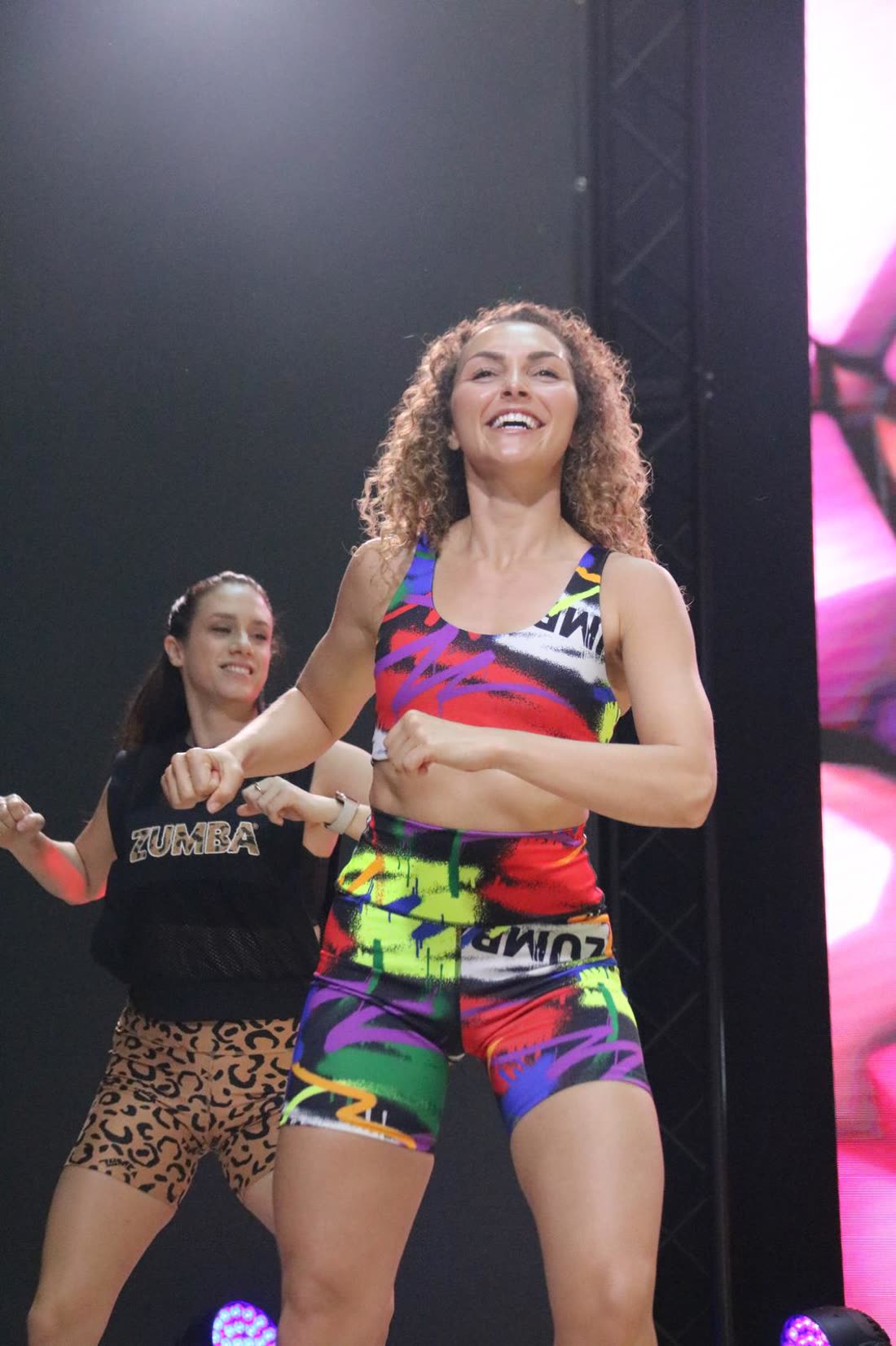 Sabrina leading a packed Zumba class on stage